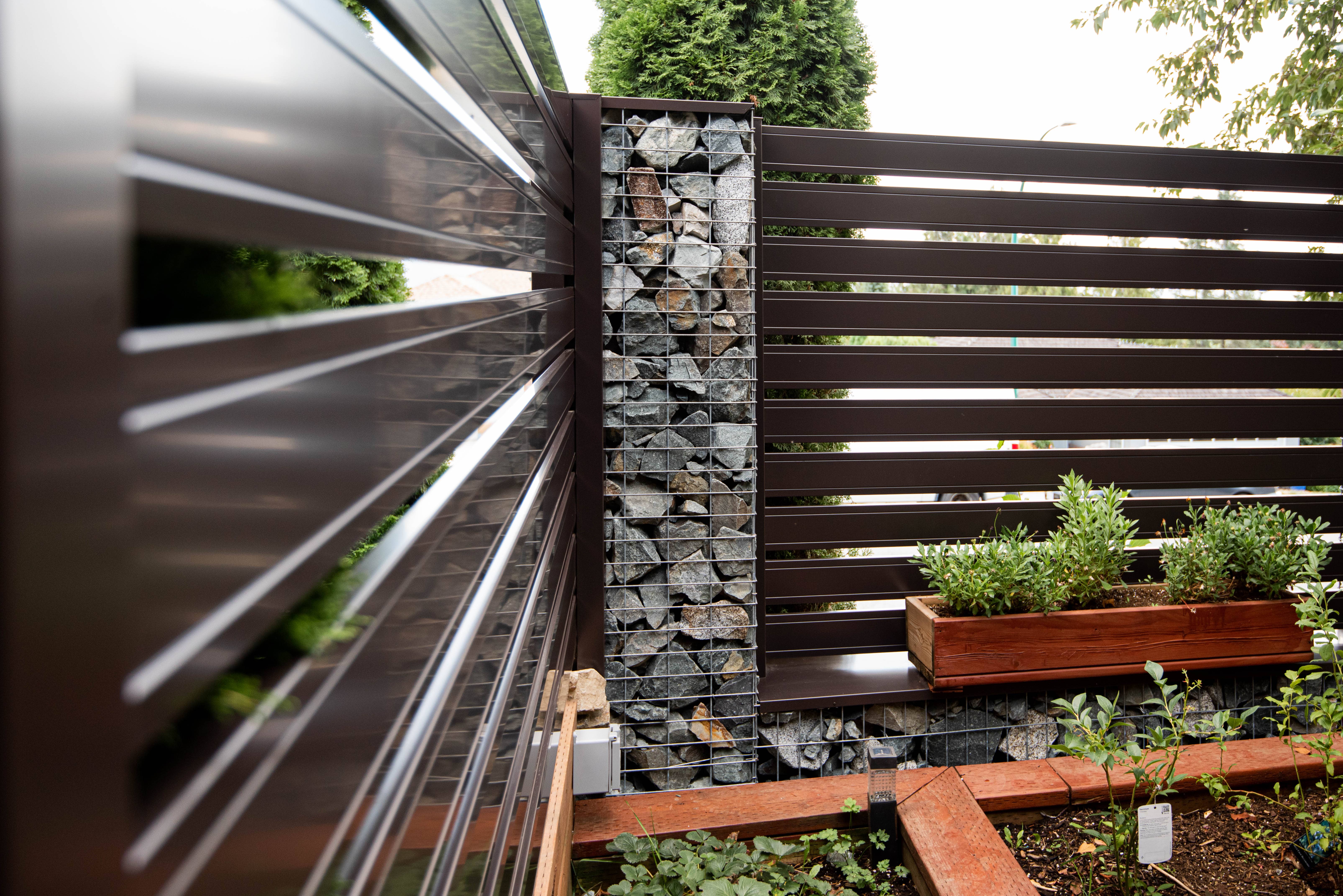 Custom metal fence and gabion-style perimeter